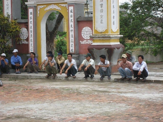 Asian men sitting on a curb