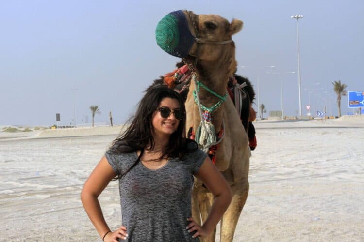 The author making friends with camels, in addition to other expats in the Middle East.