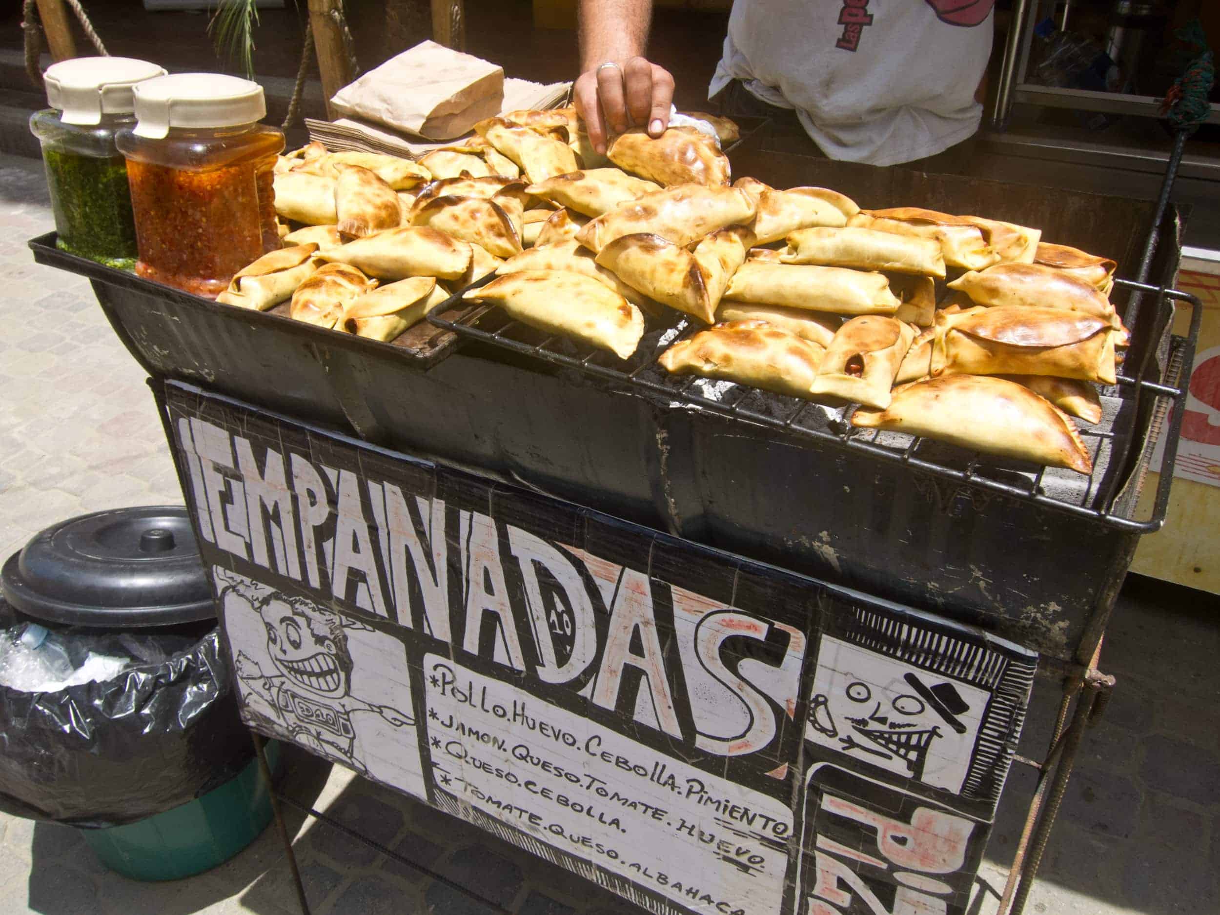 An Argentinian sells empanadas for $1 apiece on the street