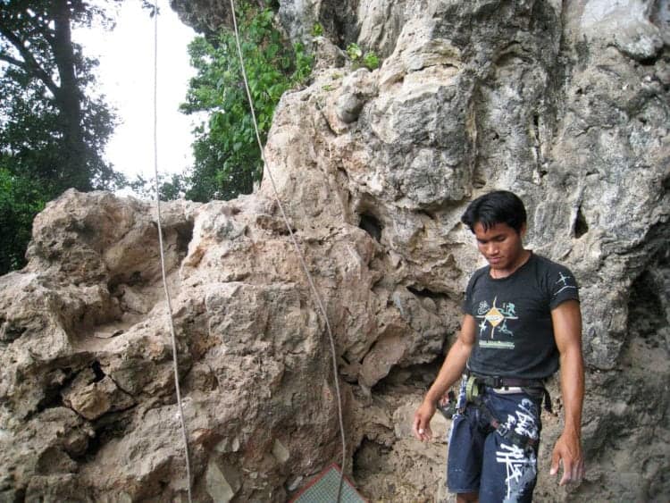 A rock climbing guide in Laos prepares to belay me