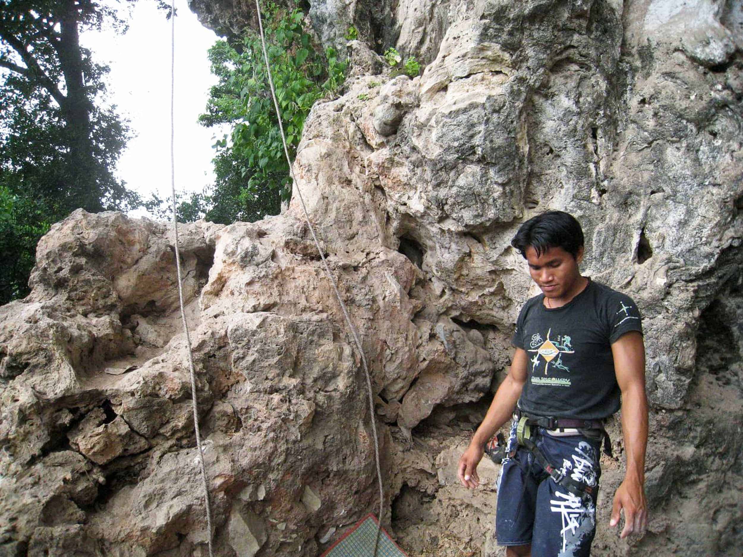 A rock climbing guide in Laos prepares to belay me