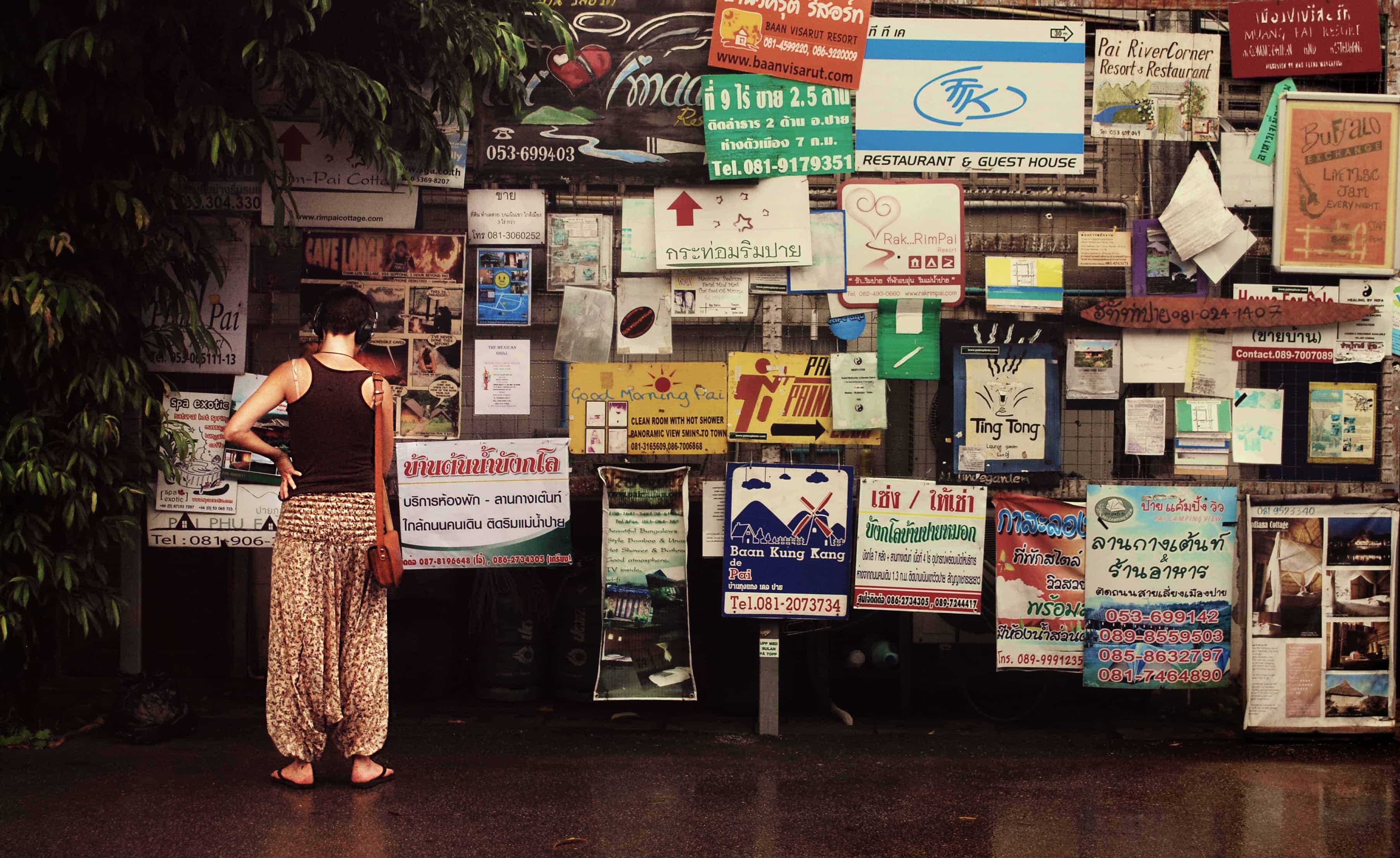 A traveler looks over a bulletin board 