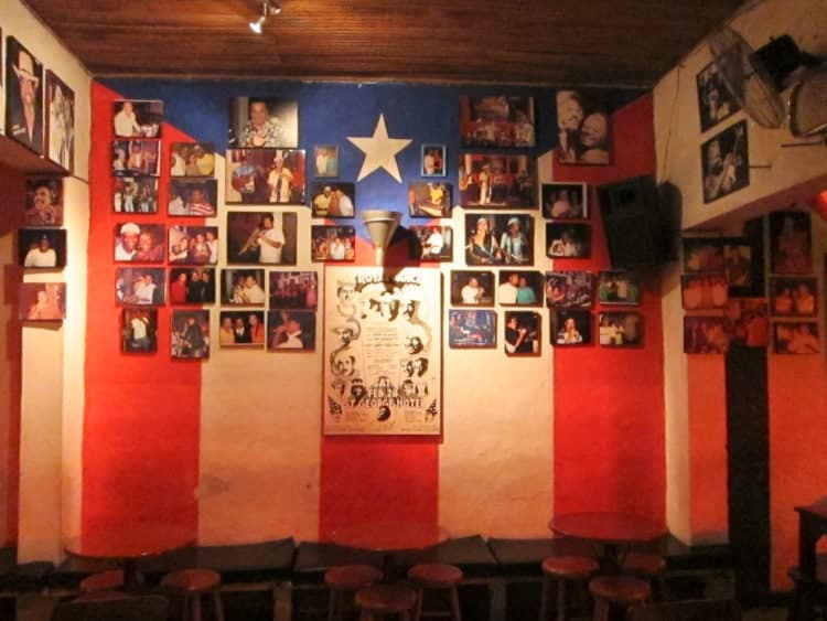 Photos of salsa musicians line a wall at Zaperoco bar in Cali, Colombia