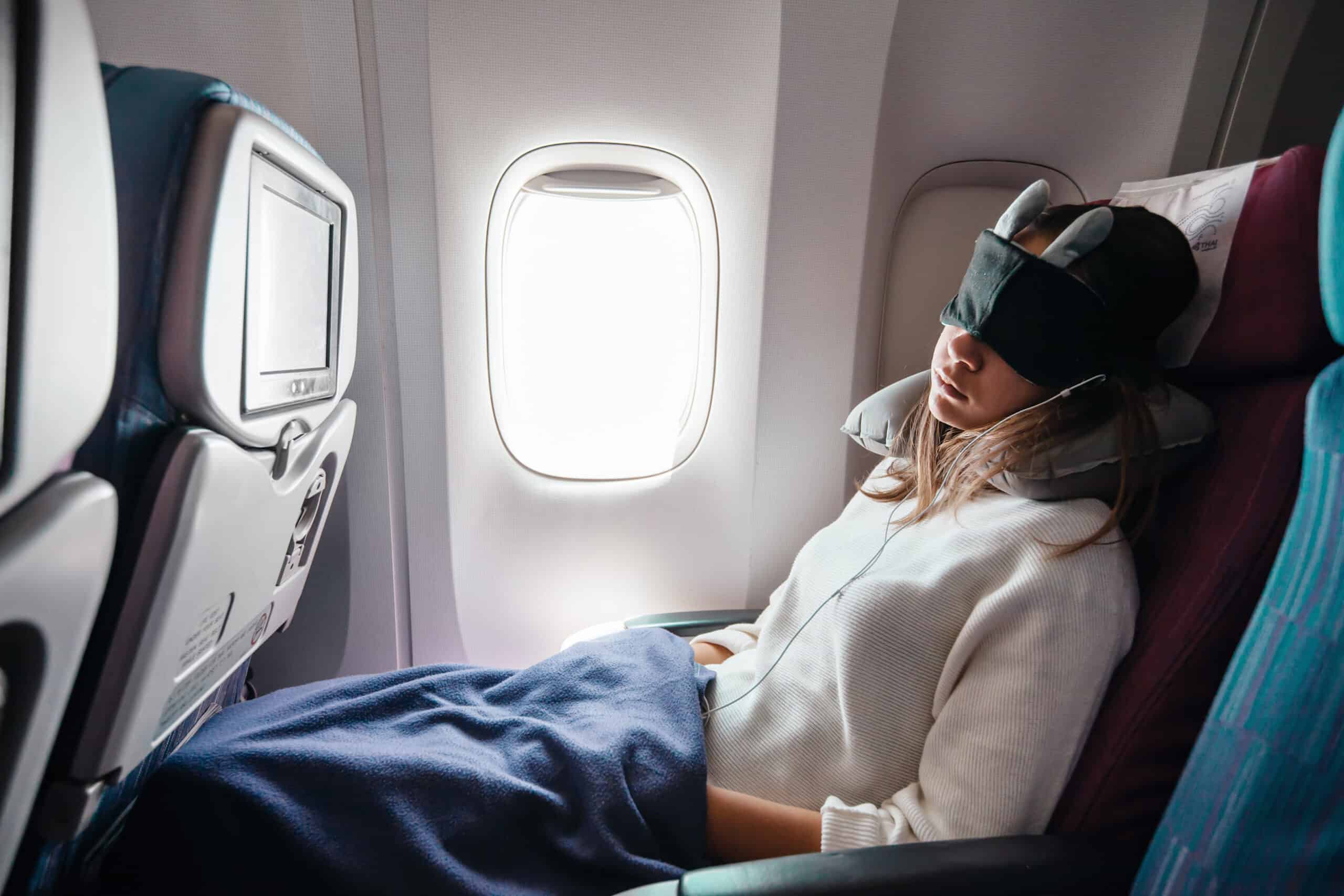 A Female Passenger Traveling by Plane Sleeping on Cushion Airplane