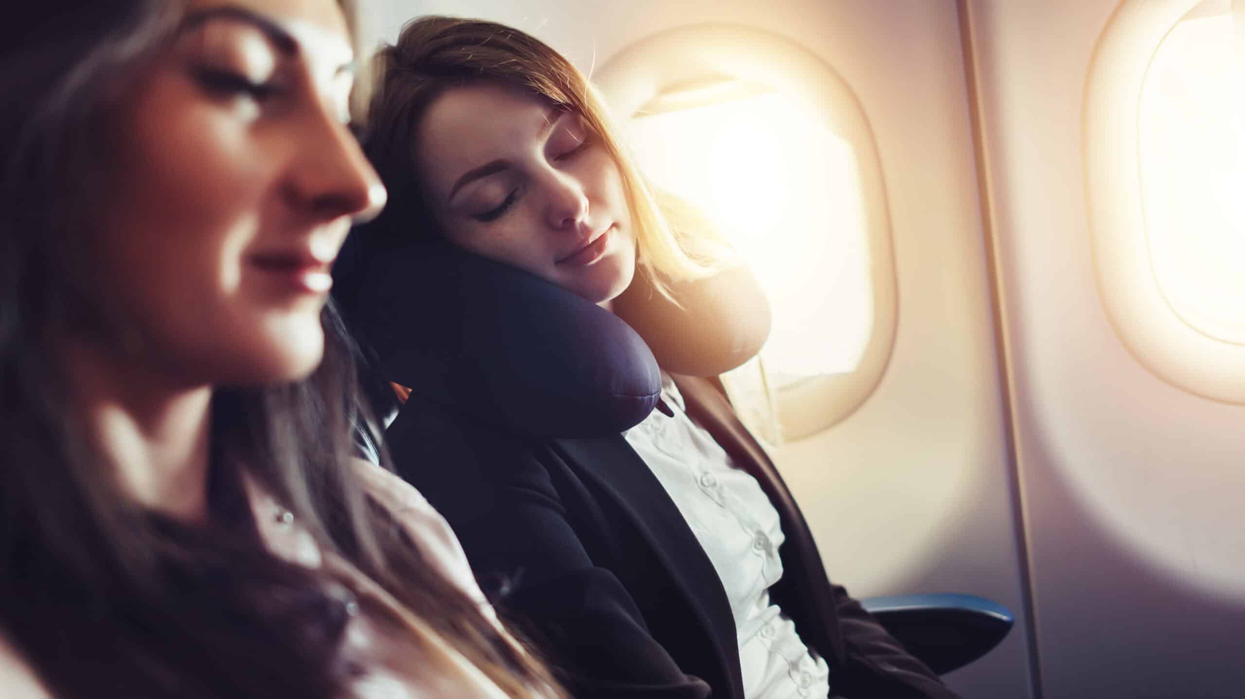 A woman asleep on a neck pillow