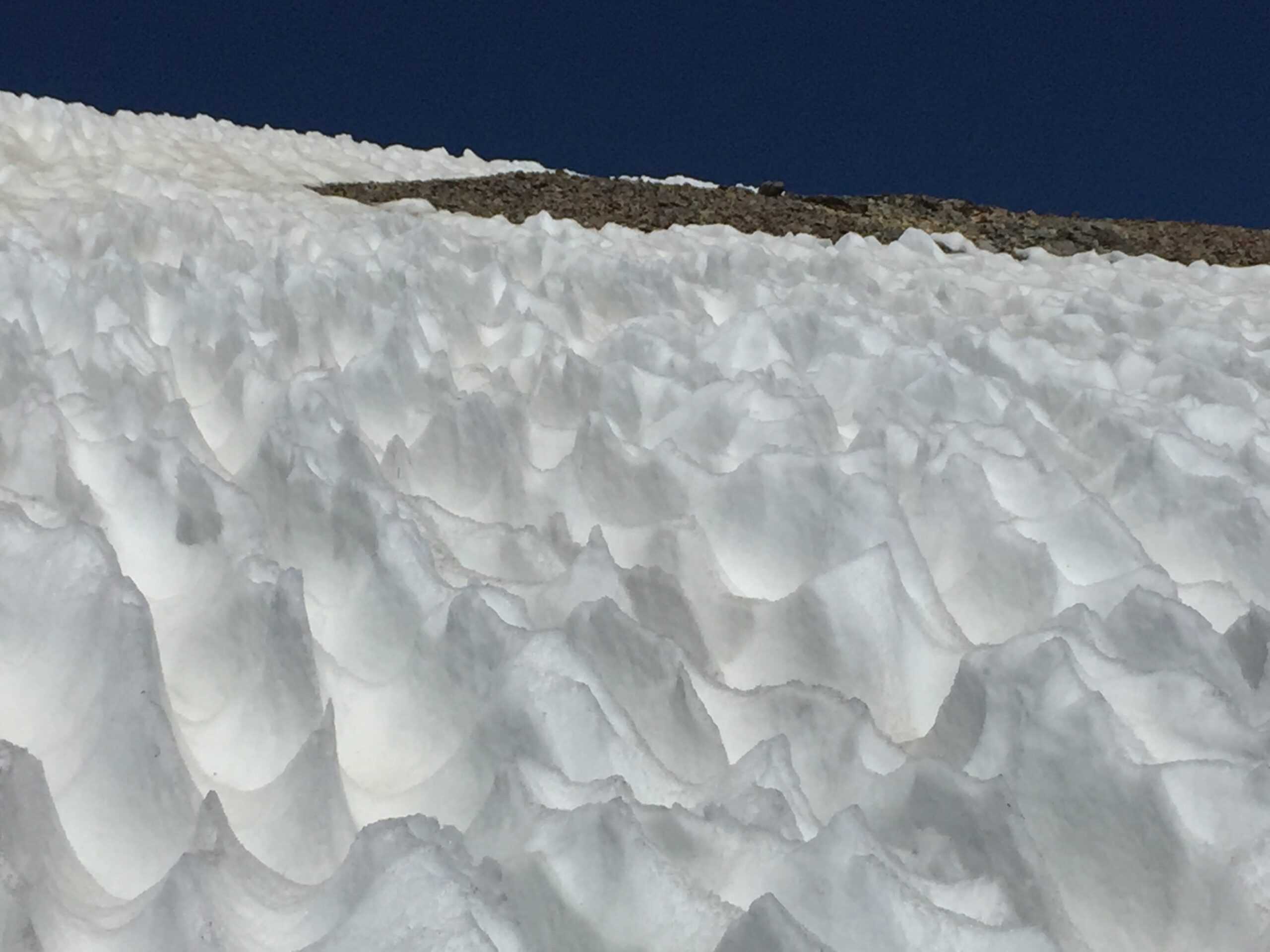 Deep sun cups on summer snowfields