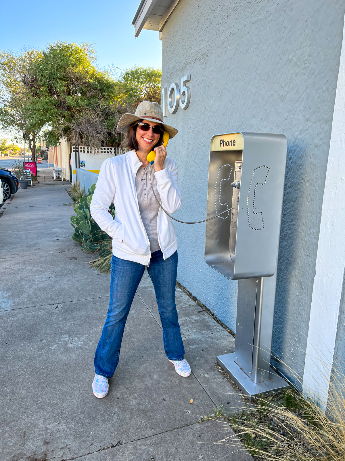 Kel listening to "Shake It Off" by Taylor Swift on a faux payphone in Marfa, Texas