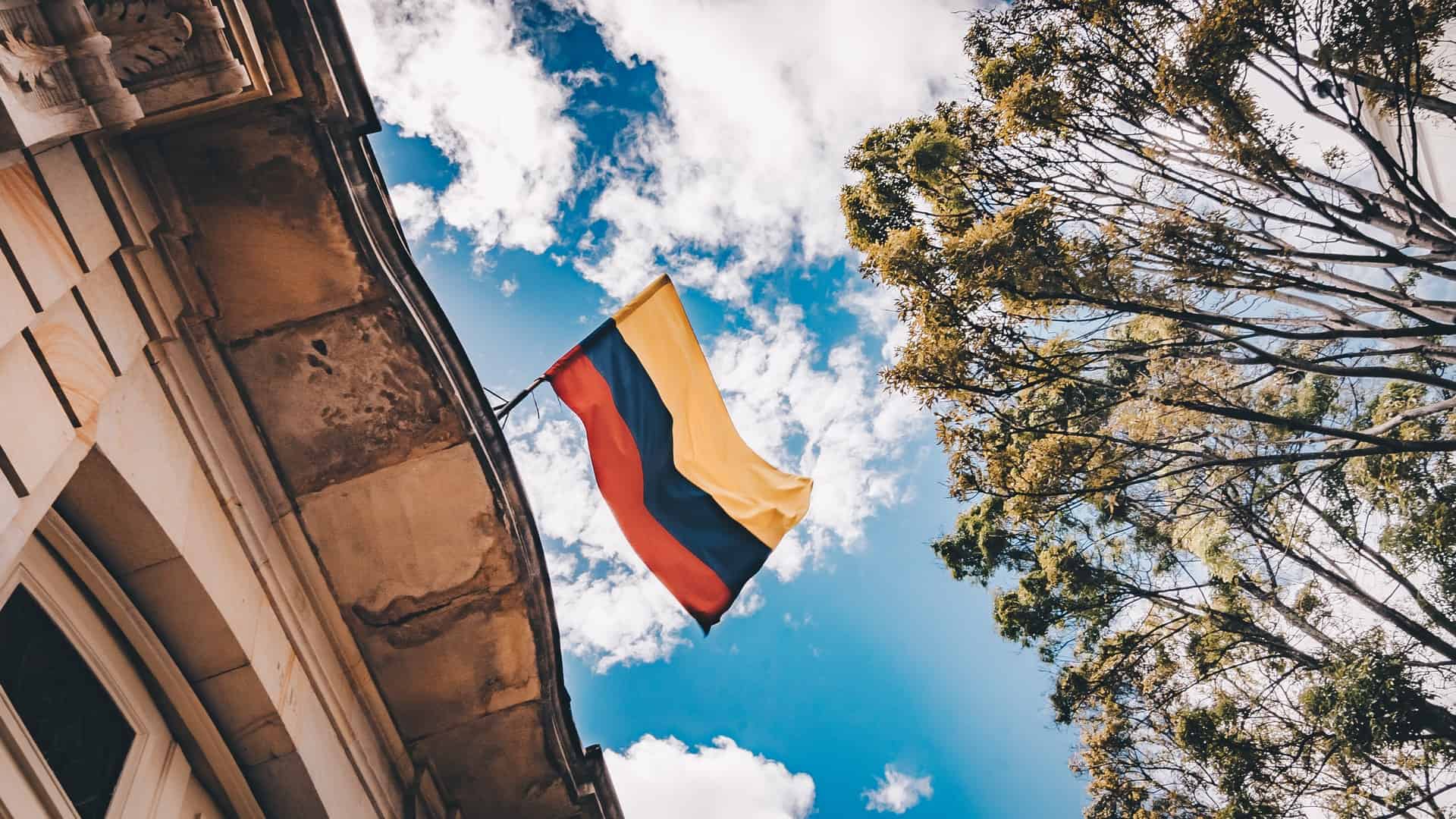 A Colombian flag in a blue sky