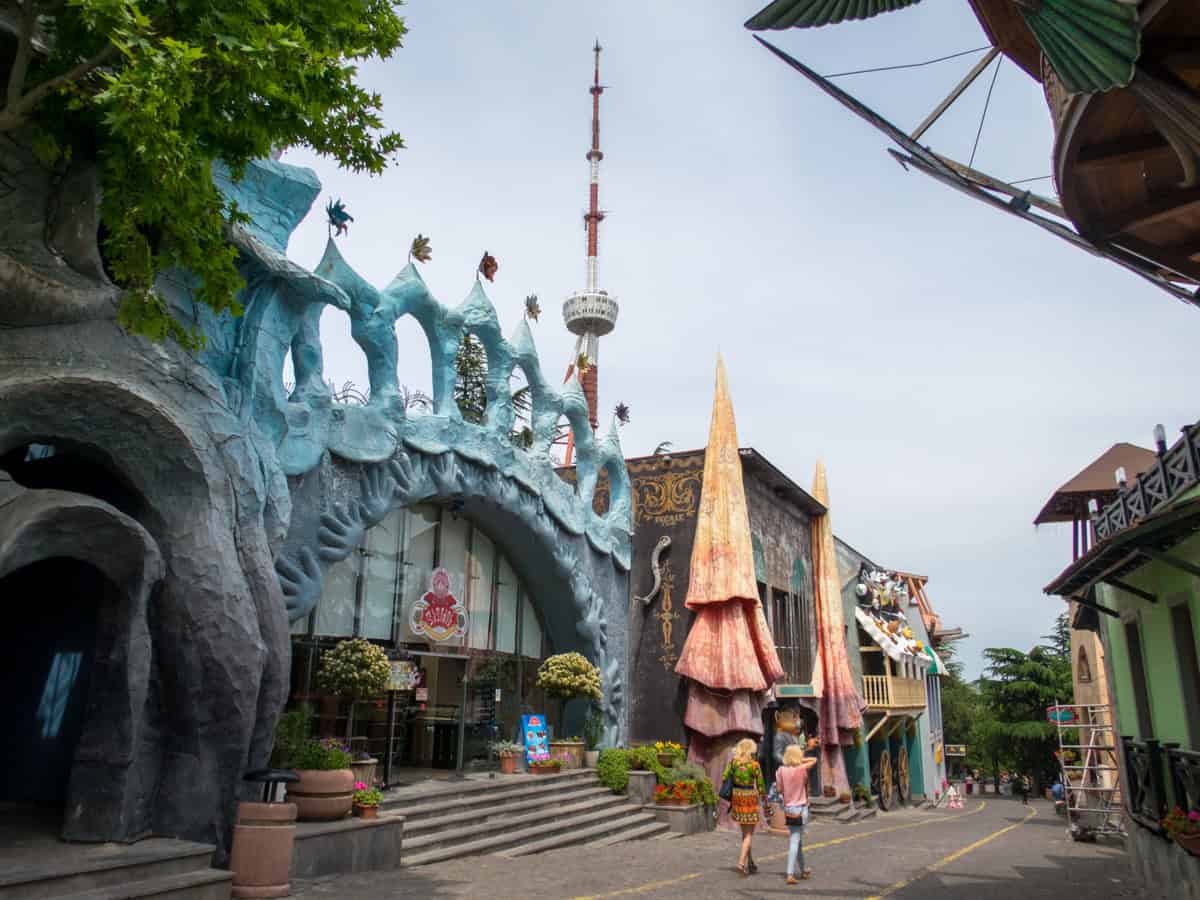 Women walking amid carnival rides in Mtatsminda Park