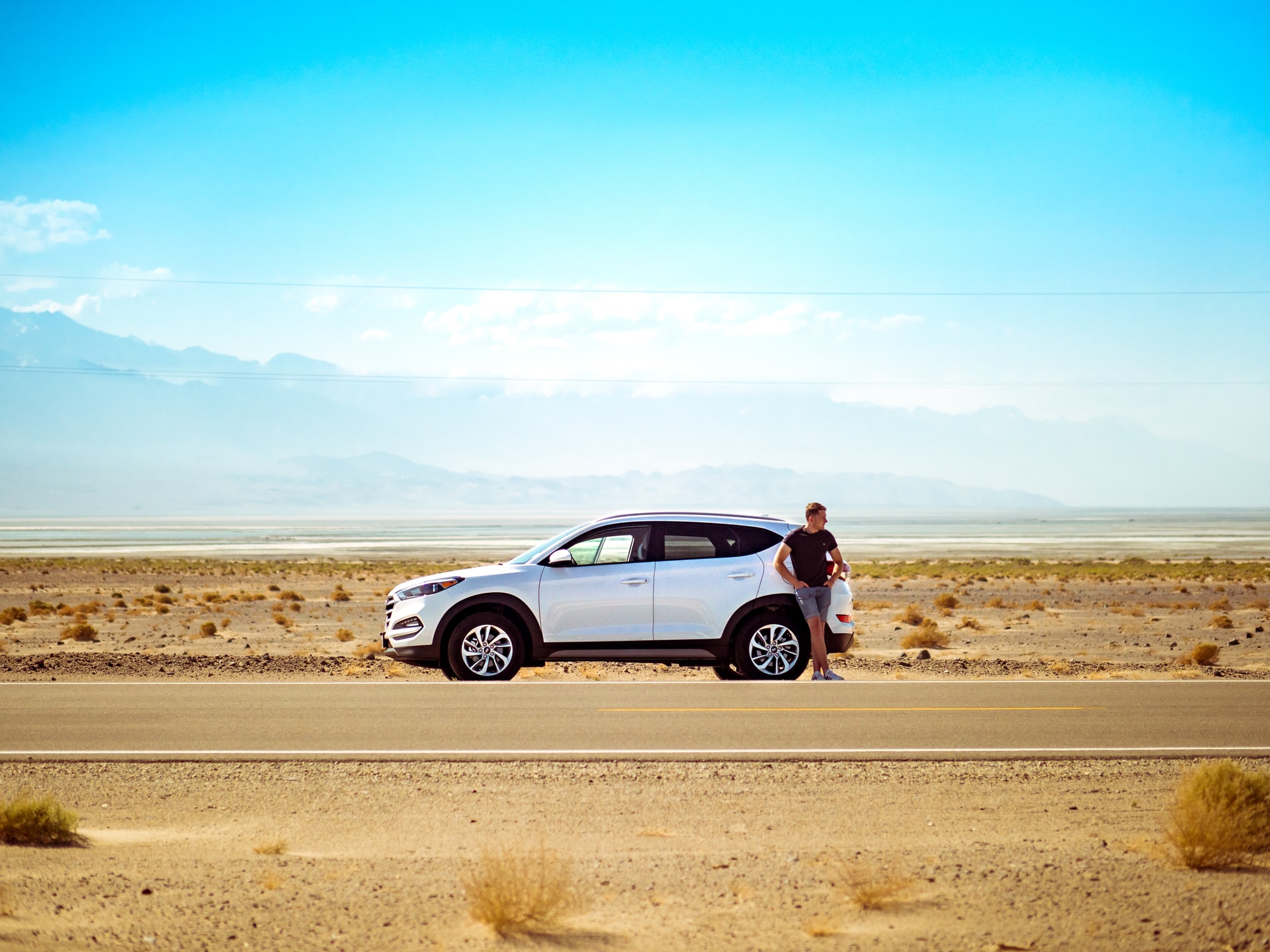 A key car rental tip is choosing the right type of vehicle for your trip. Pictured: car and driver in Death Valley, USA (photo: Jamie Street)