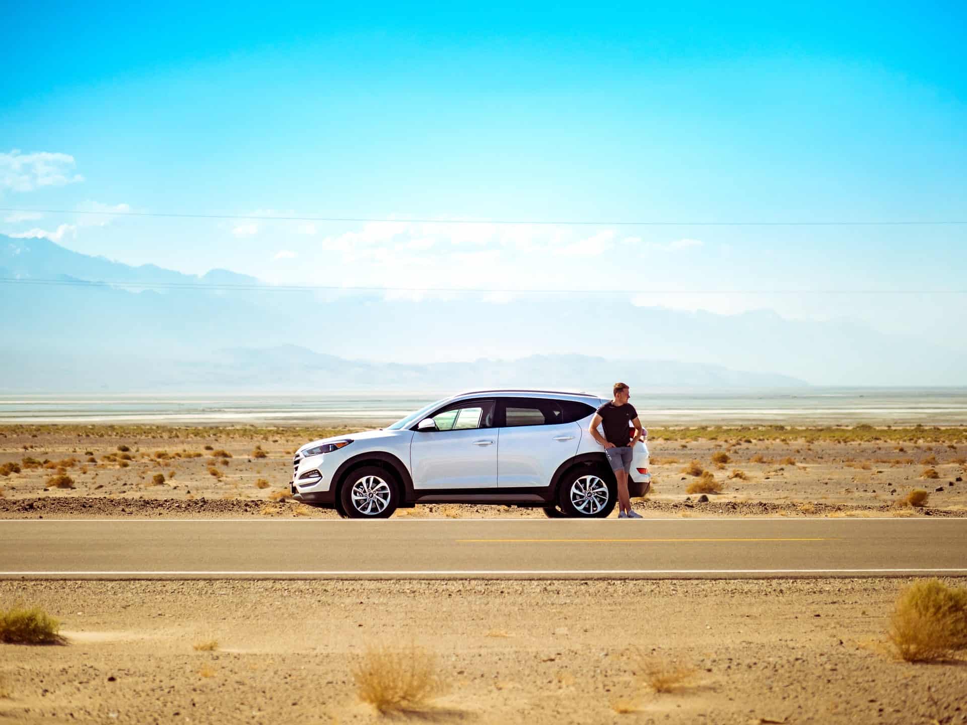 A key car rental tip is choosing the right type of vehicle for your trip. Pictured: car and driver in Death Valley, USA (photo: Jamie Street)