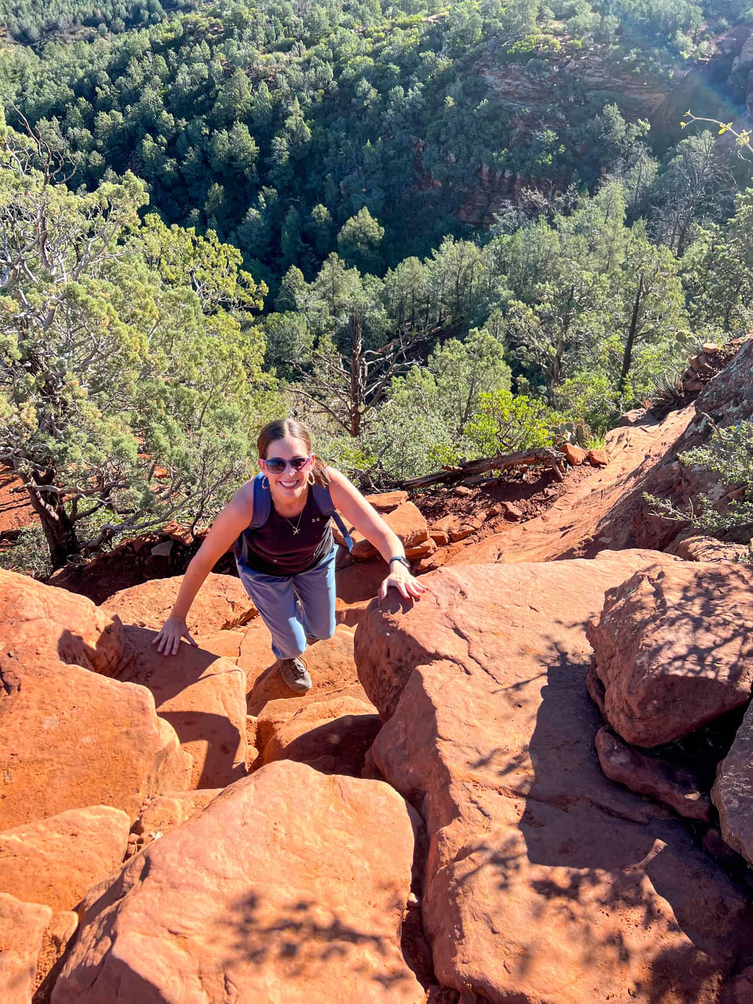 Kel climbing the red rocks on her way up the Devil's Bridge Trail