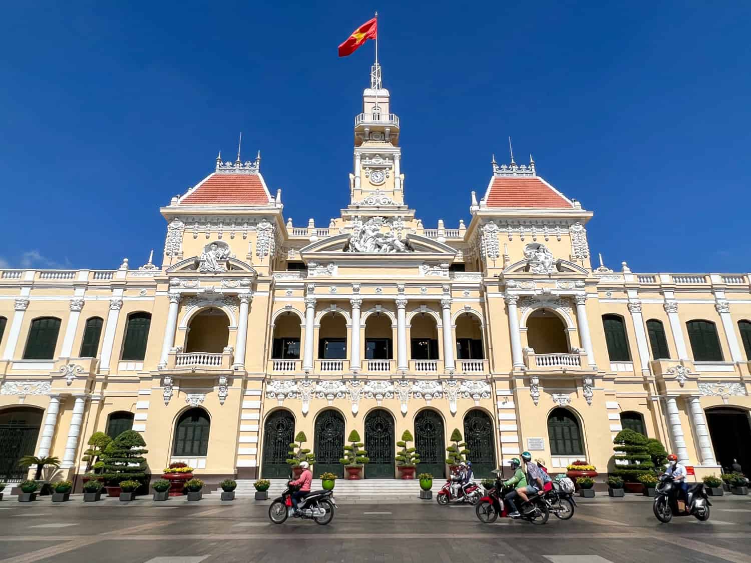 Motorbikes drive past the People's Committee Building Saigon in Saigon