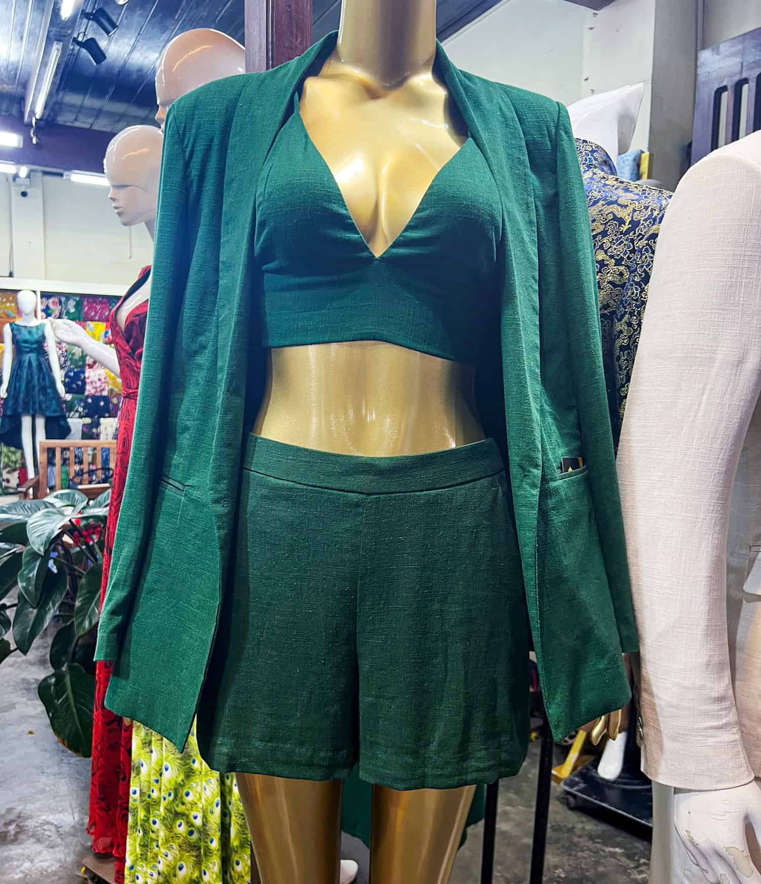 Women's green shorts, shirt, and jacket at a tailor shop 