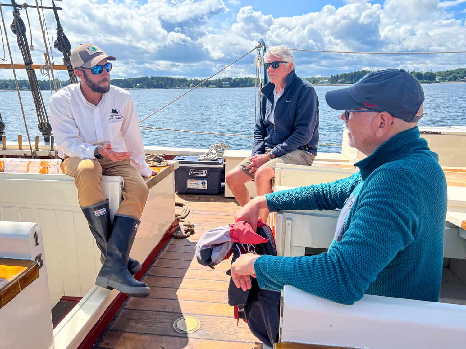 Captain Justin Schaefer talks with guests during the Maine Sip & Sail Cruise