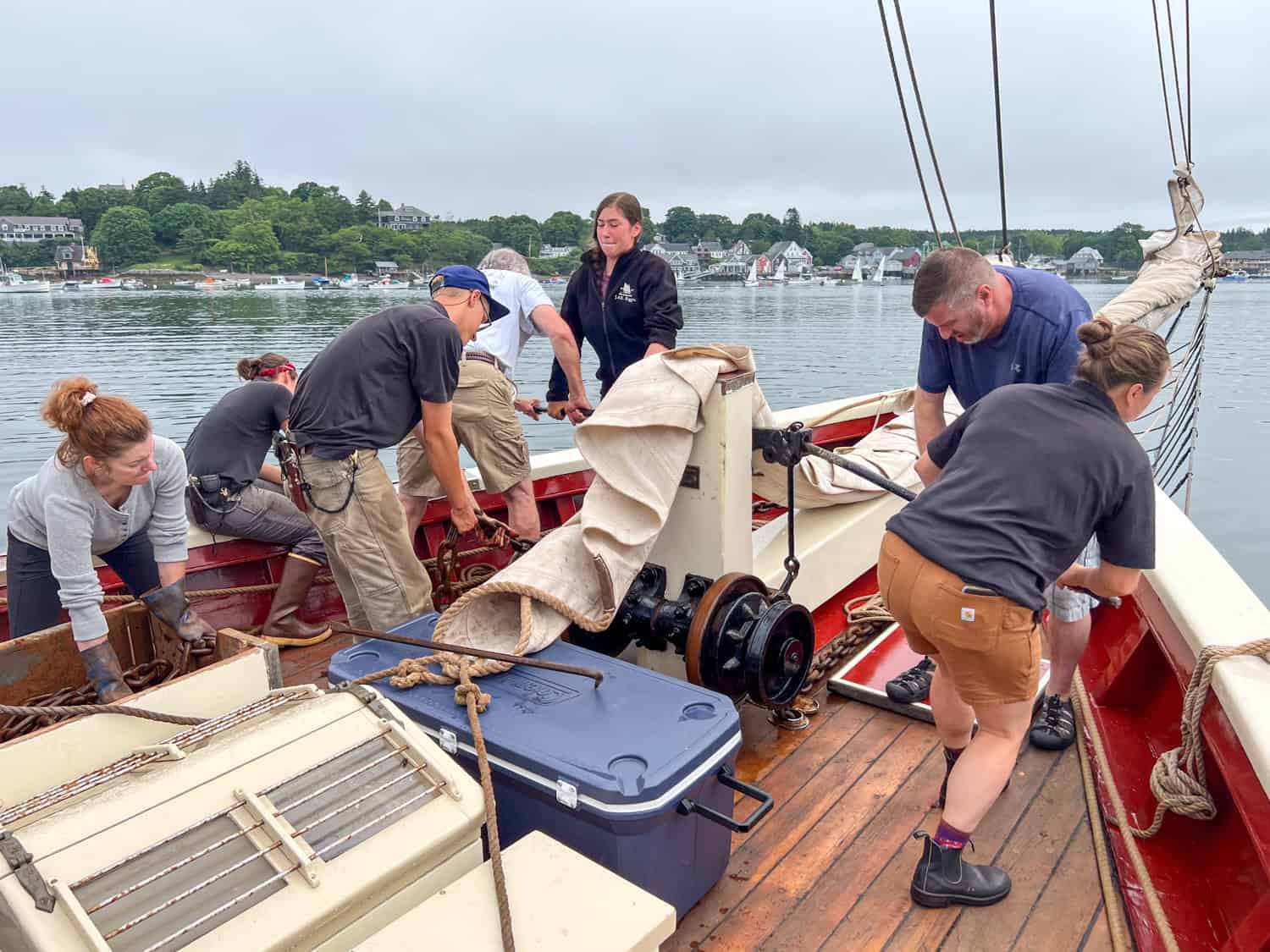 Seven guests and crew work together to raise the iron anchor.