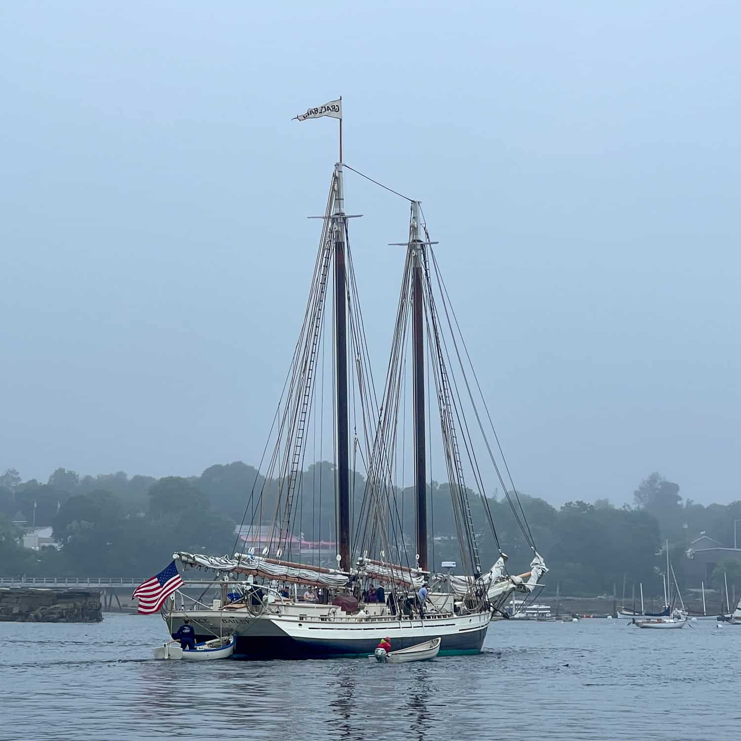 A yawl boat pushes the Schooner Grace Bailey out of Rockland Harbor.