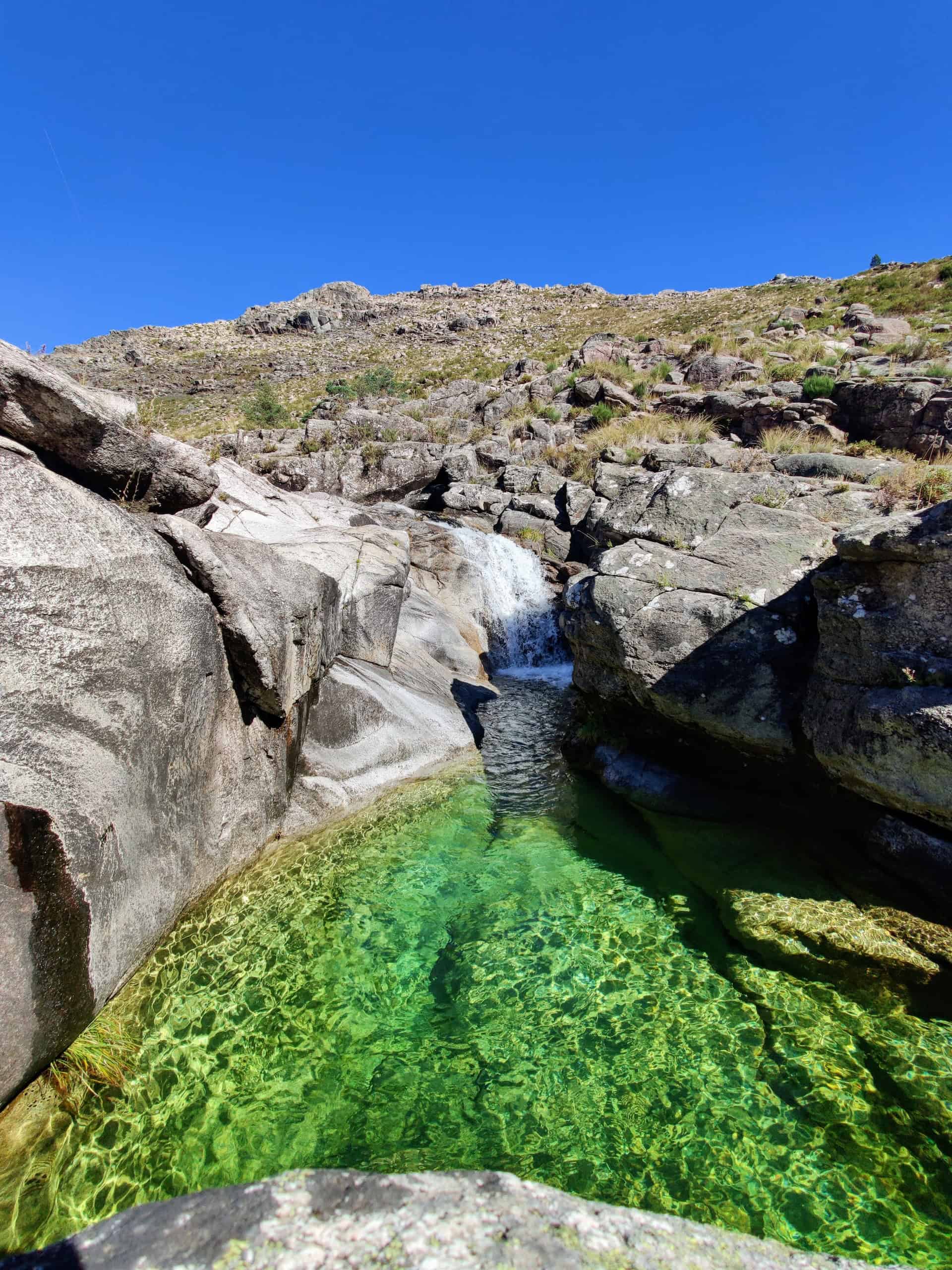 Waterfall emptying into a green-colored pool in Peneda-Gerês National Park (photo: Micael Rodrigues)