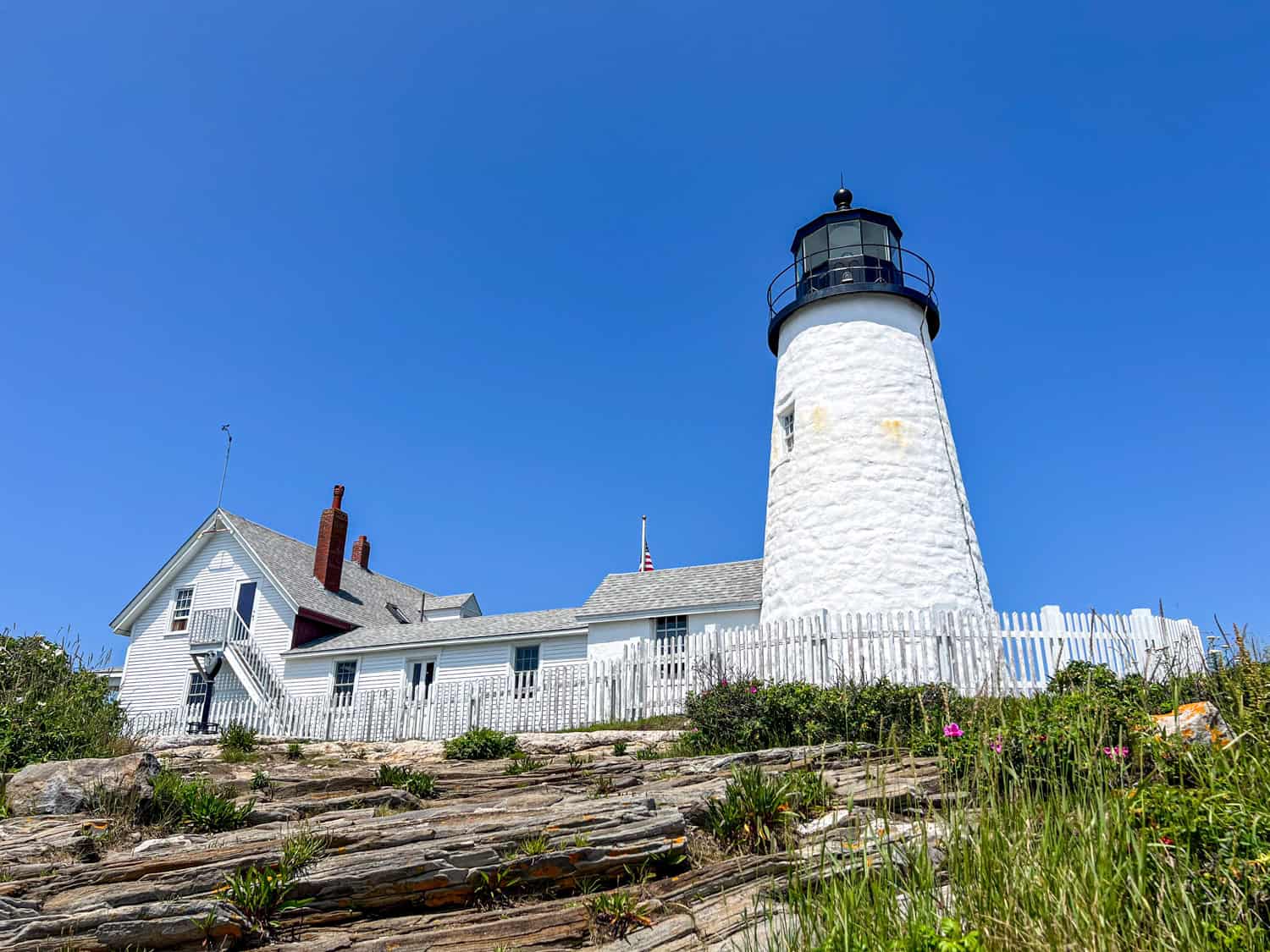 Pemaquid Point Lighthouse as seen from below along the rocky coastline of Maine.