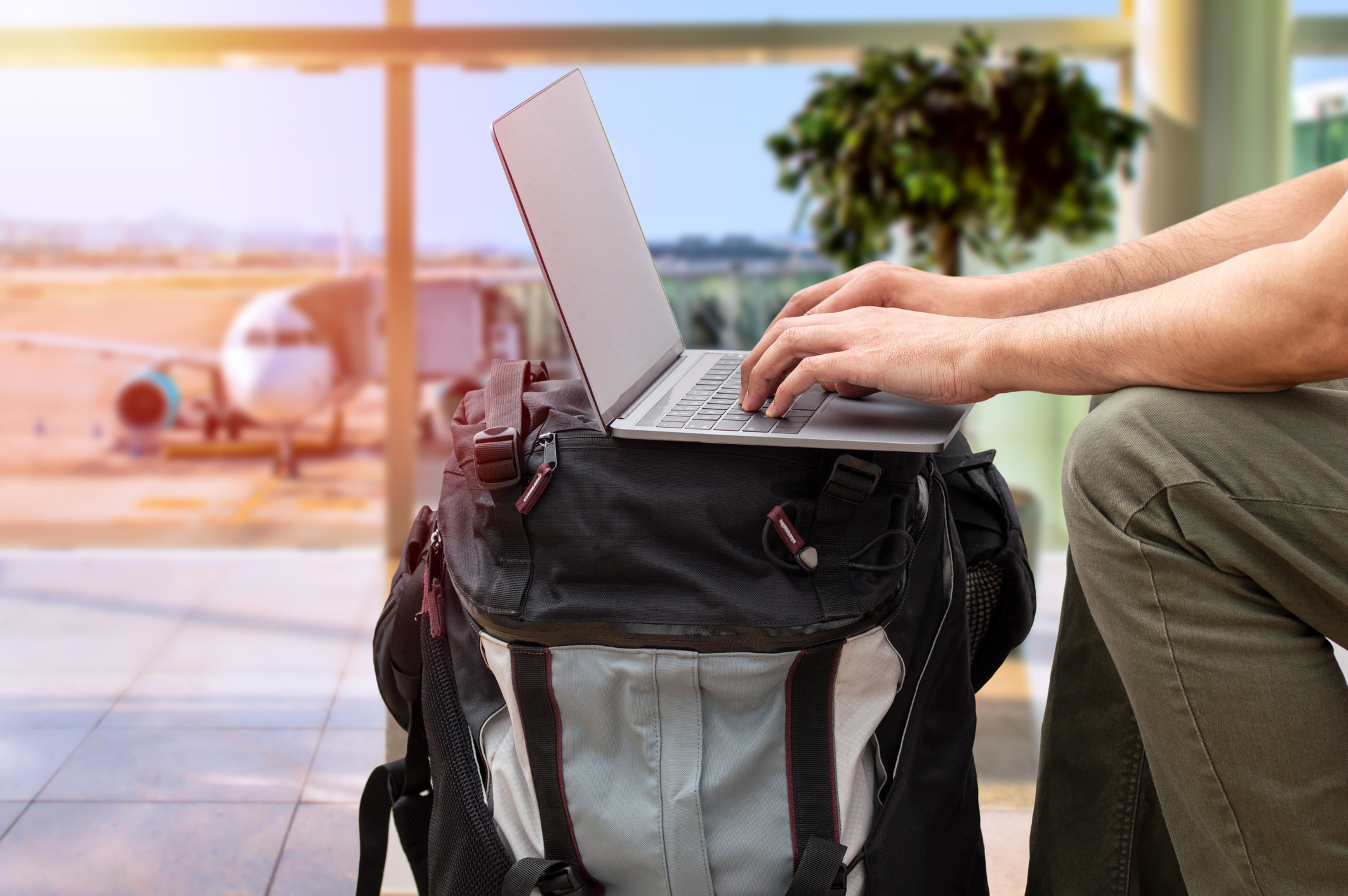Working on a laptop at an airport. Digital nomads are experts at minimalist packing. (photo: iStock)
