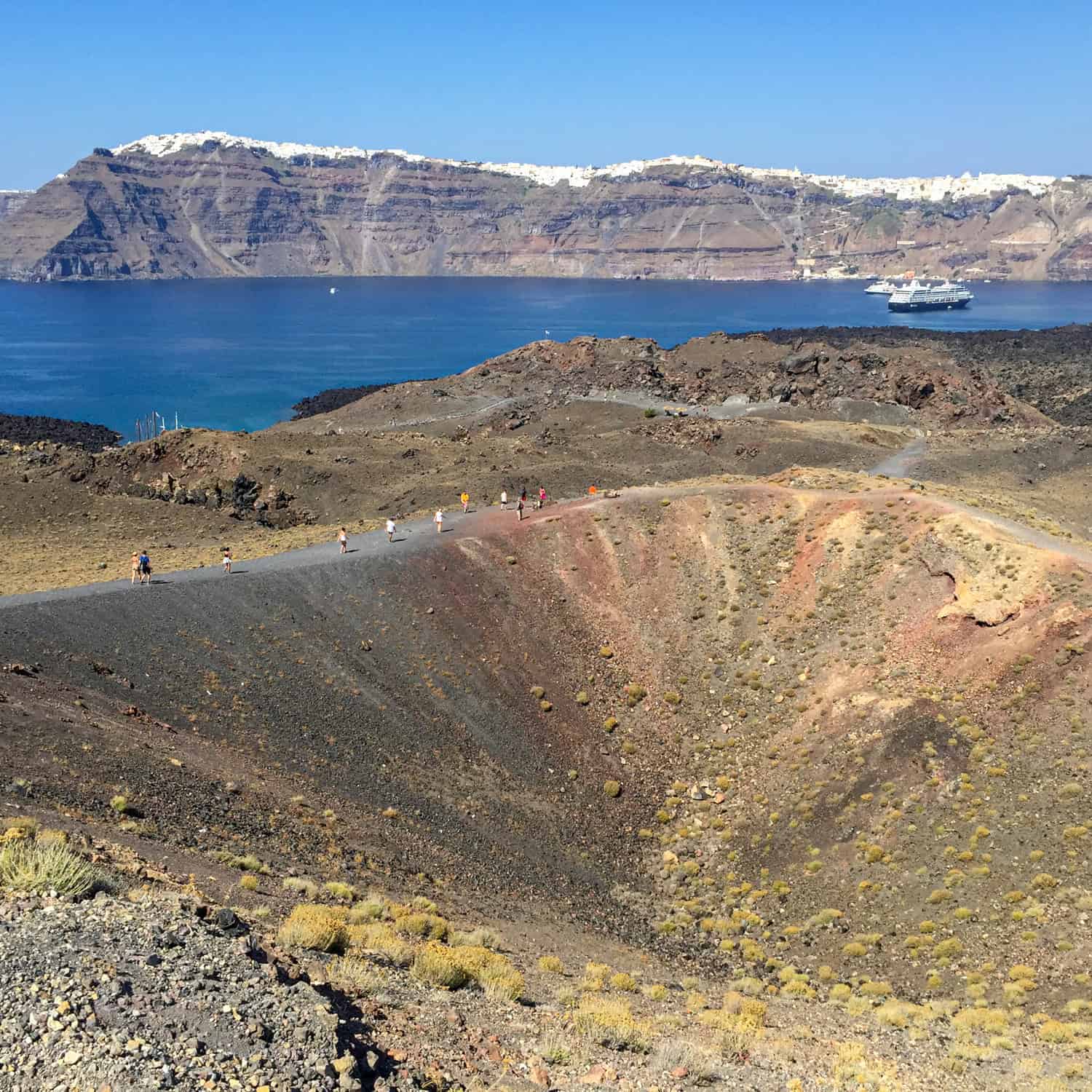 View of whitewashed villages on Santorini from the Tholos Naftilos volcano on Nea Kameni Island.