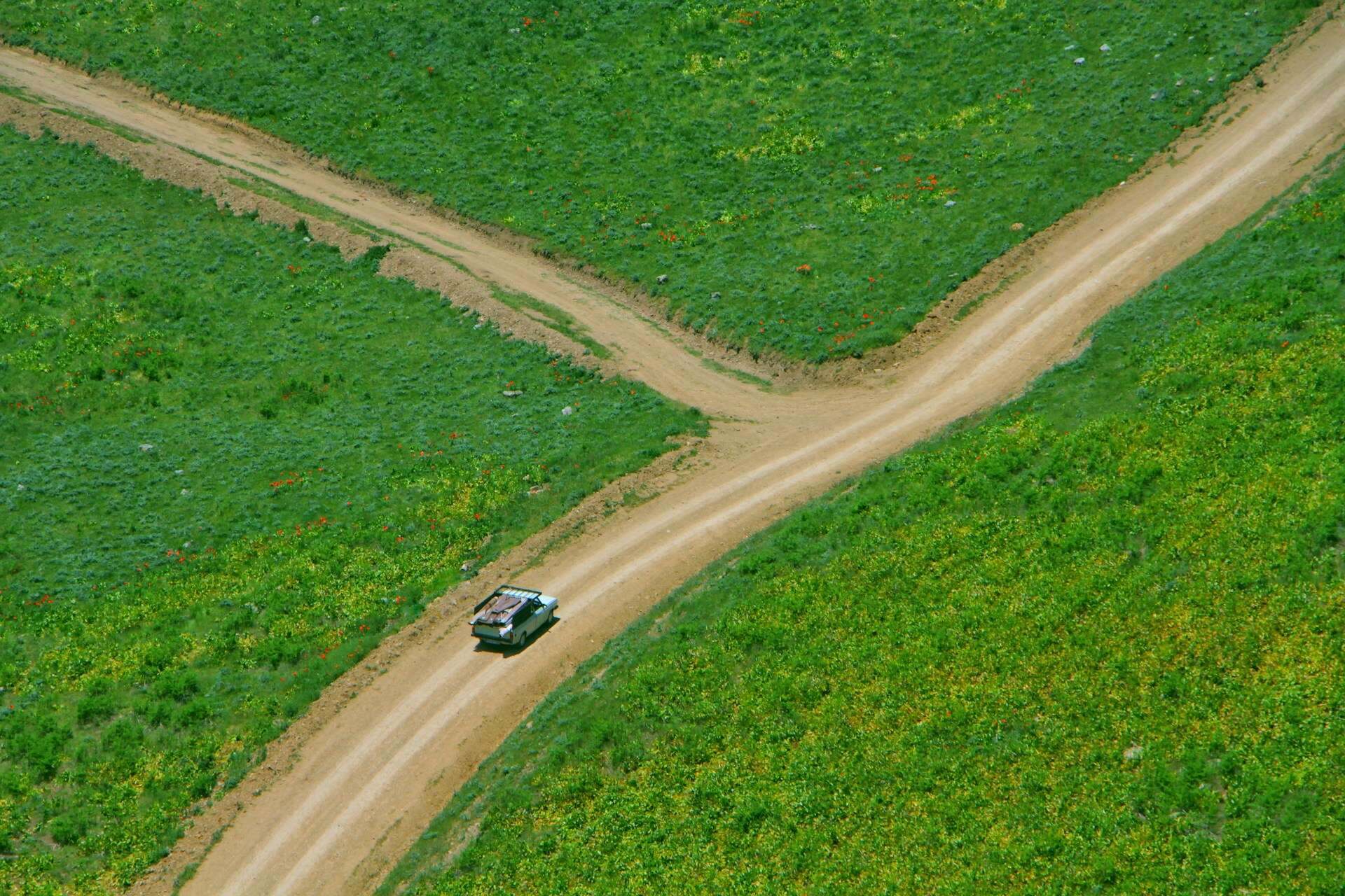 An off-road vehicle driving on a dirt road (photo by Hasan Almasi, Unsplash).