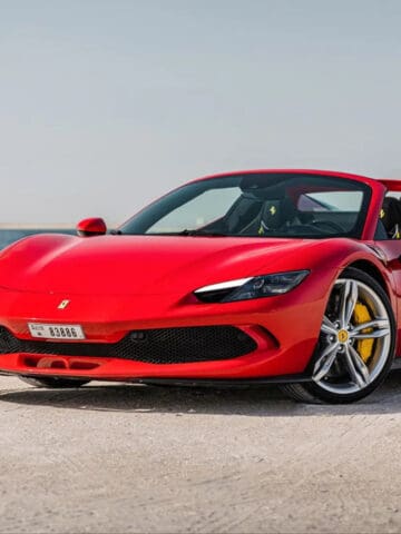 A red Ferrari 296 on the beach (image provided by Trinity Car Rental).