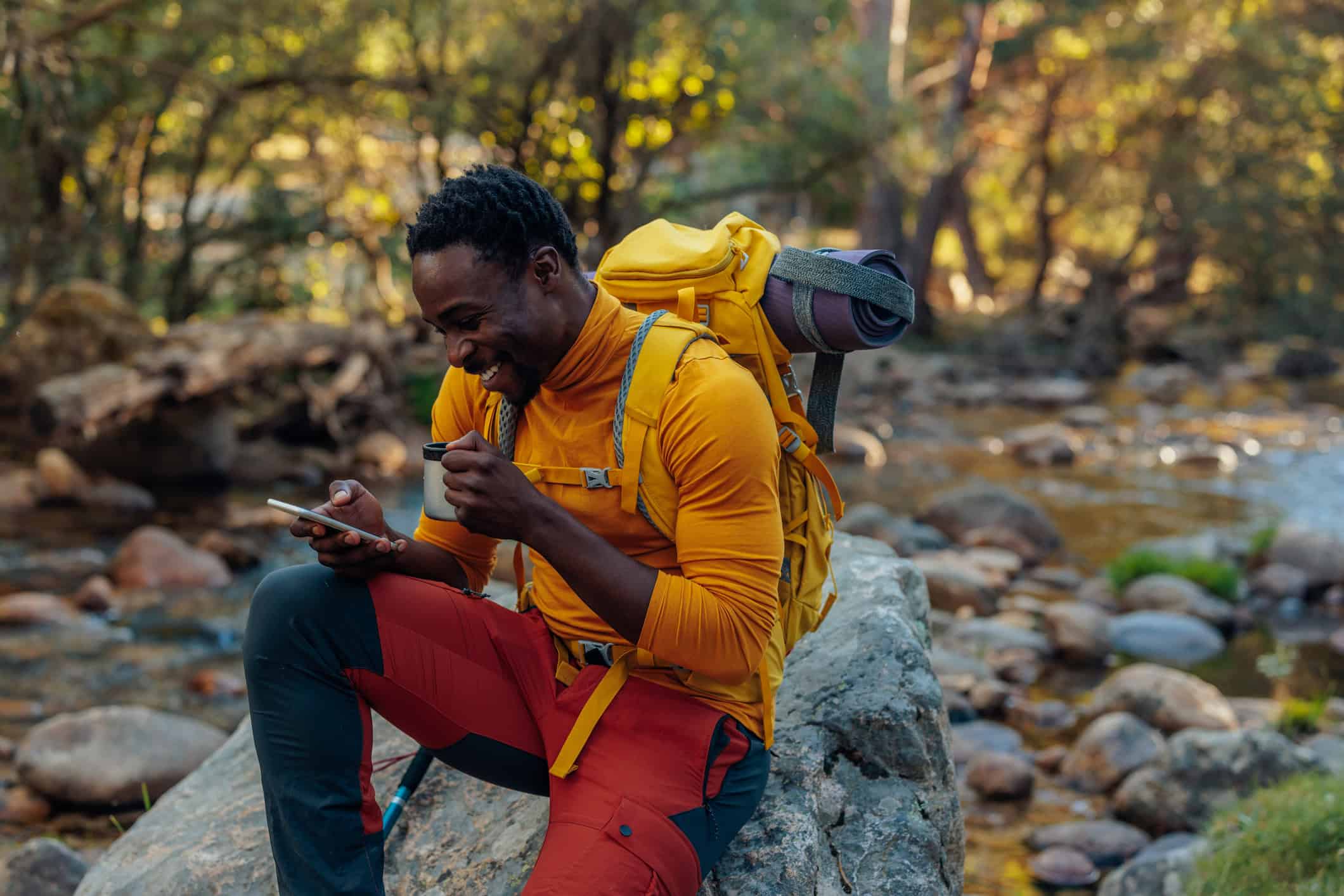 A hiker in Europe checks his phone thanks to eSIM connectivity (photo: Bernardbodo, iStock license).