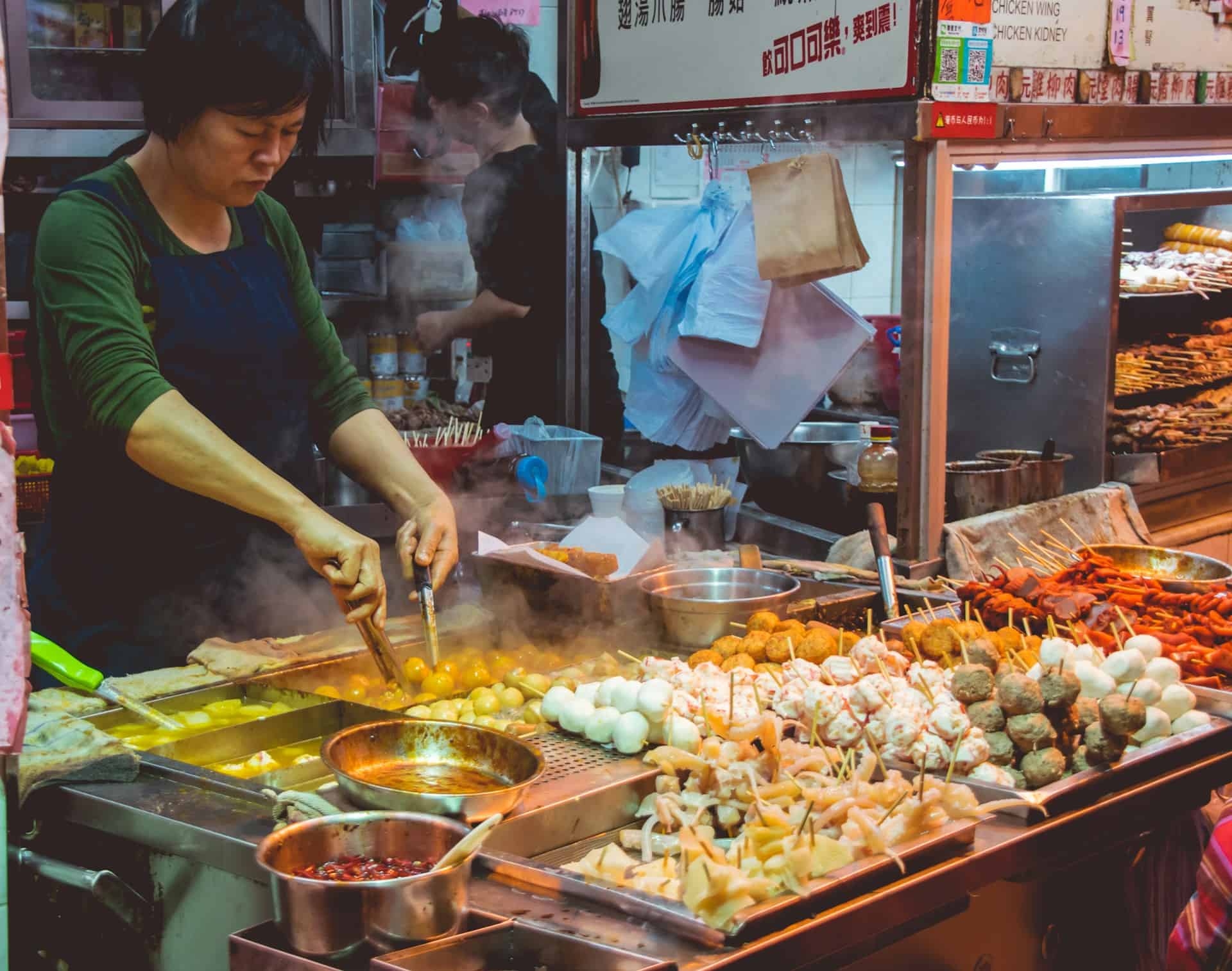 A woman prepares street food in Hong Kong (photo: Vernon Raineil Cenzon, Unsplash).