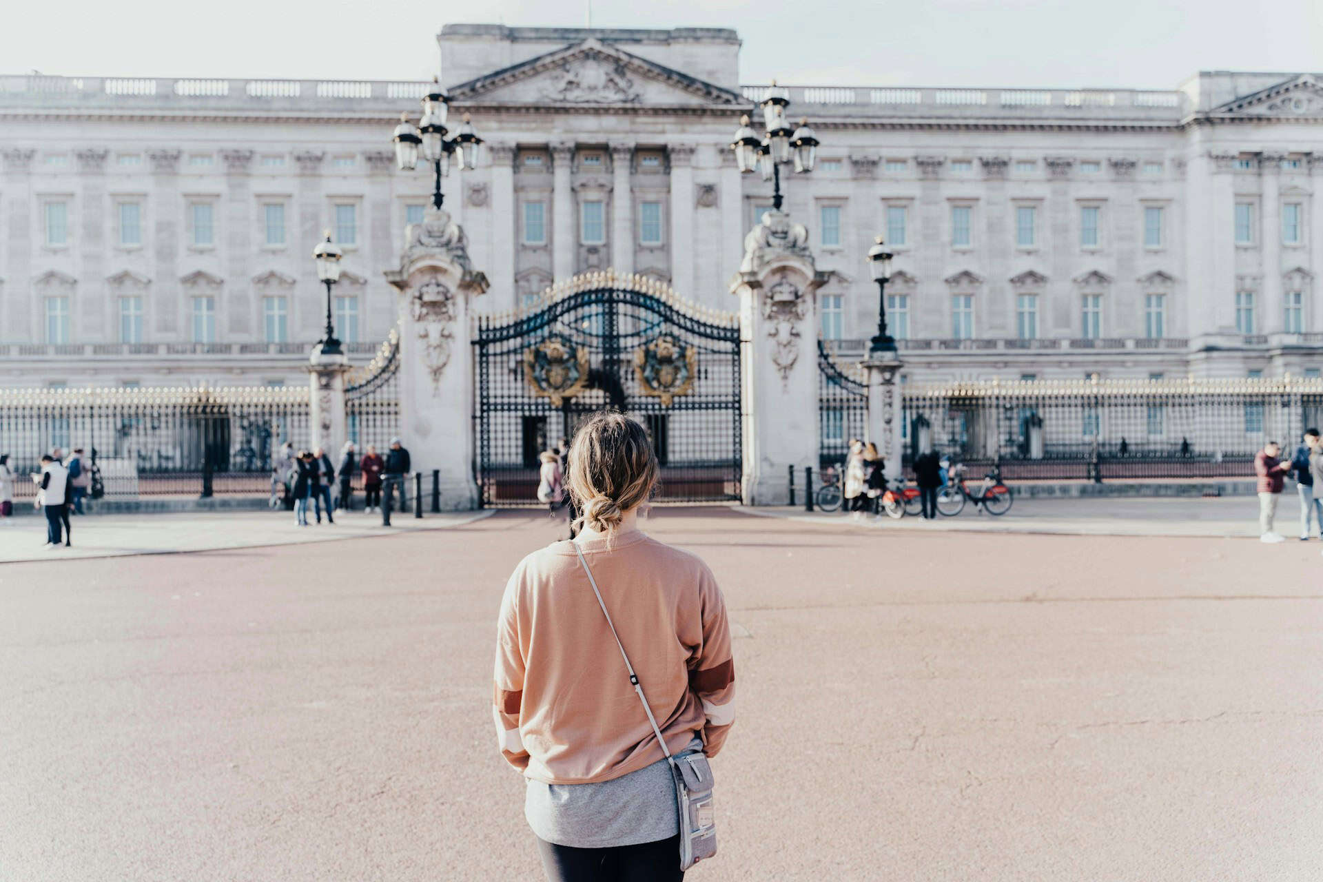 A woman standing in front of Buckingham Palace (photo: Anna Claire Schellenberg, Unsplash).