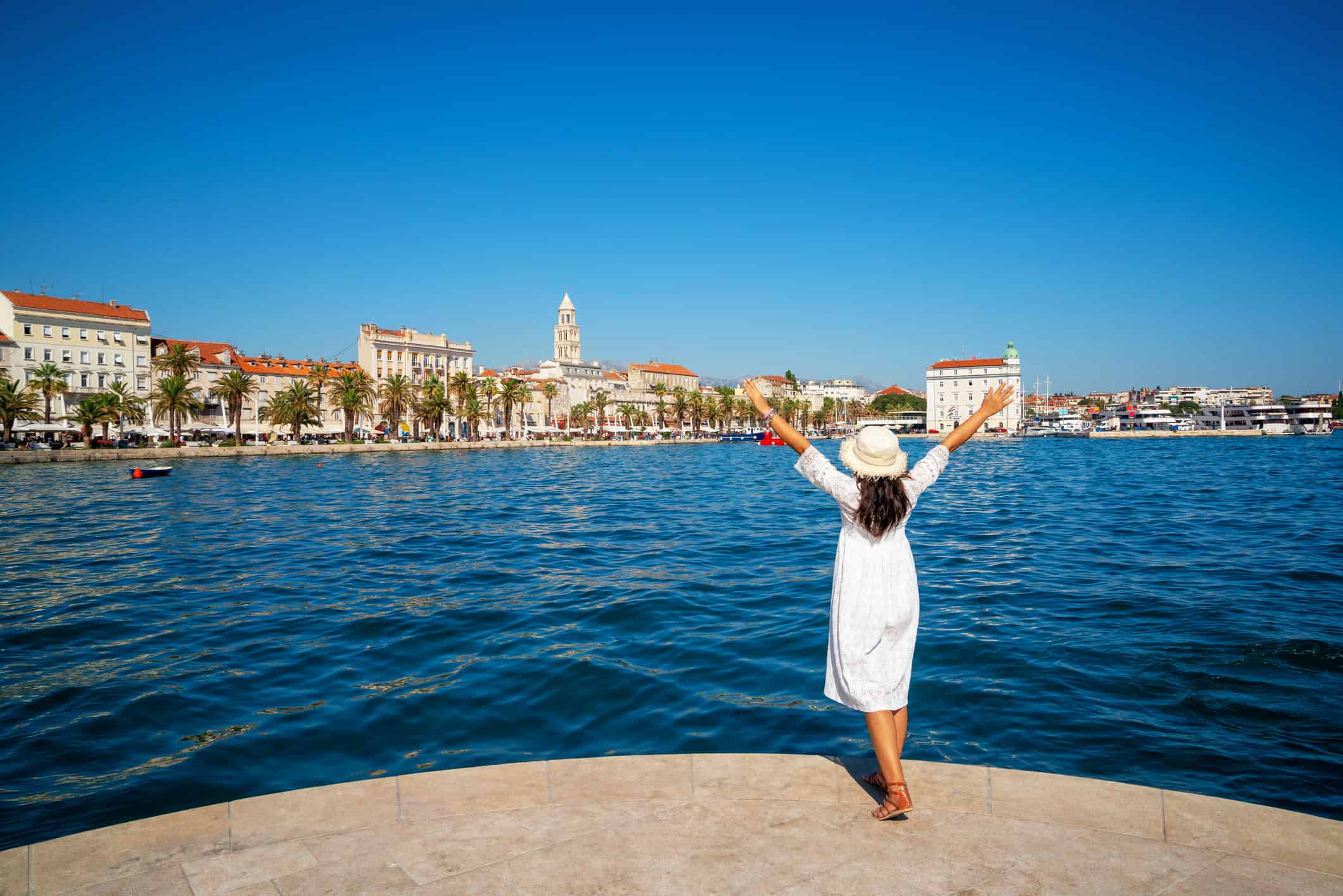 A female traveler in a white dress enjoying the old town in Split, Croatia (photo: iStock).