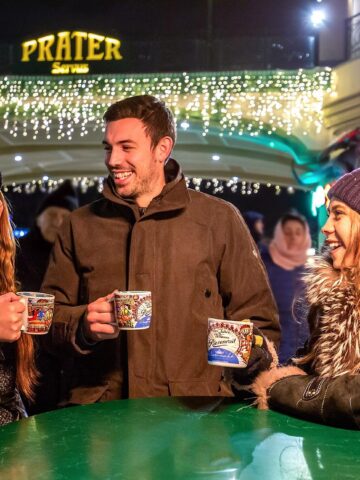 Travelers sip mulled wine at a Christmas Market in Vienna, Austria (photo: Julius Silver, Pixabay).