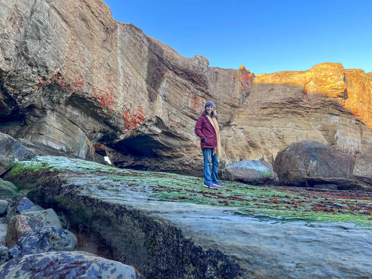 Kel standing on moss-covered rocks.