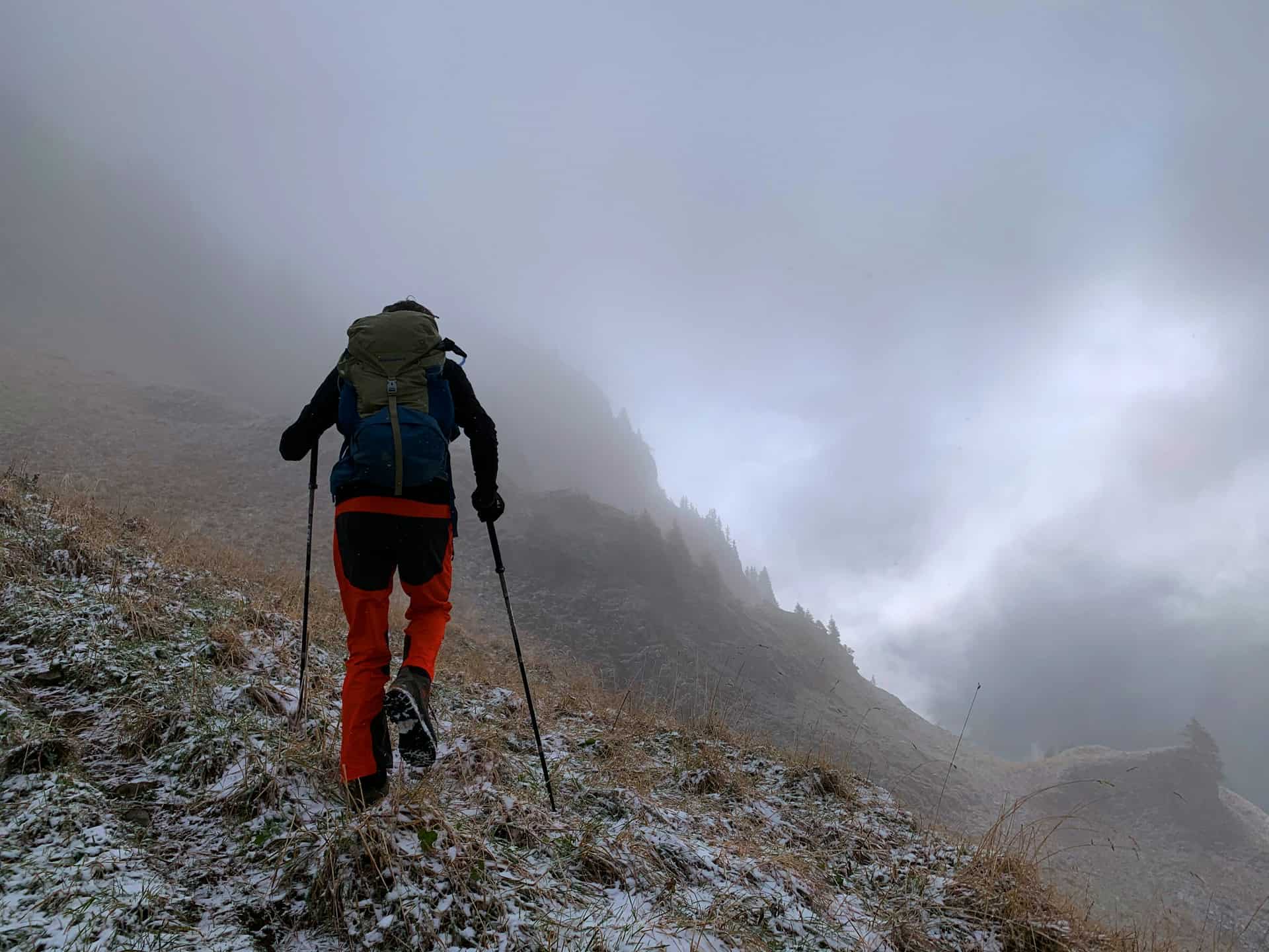 A hiker with trekking poles - Switzerland (photo: Stéphane Fellay. Unsplash).