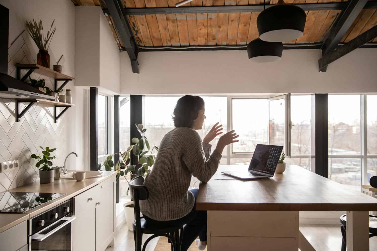 A digital nomad uses an apartment kitchen as her workspace abroad (photo: Katrin Bolovtsova, Pexels).