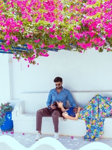 A couple together under flowers on Santorini (photo: Darshan Gujrathi, Pexels).