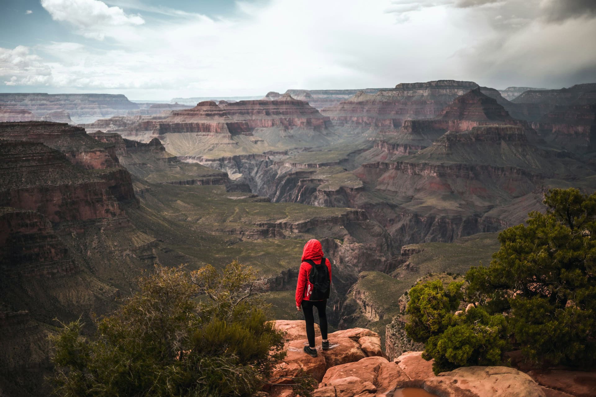A hiker in a red rain jacket at the Grand Canyon in Arizona (photo: Alexander Kaufmann, Unsplash).
