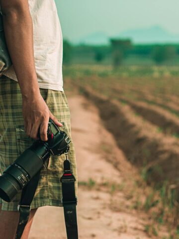 Man holding DSLR camera (photo: Mong Mong, Pexels).