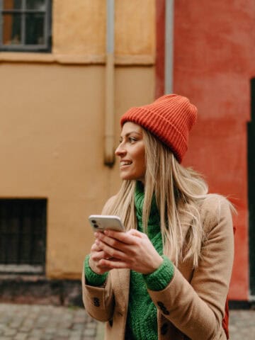 Traveler using a smartphone on a cobblestone street in a European city