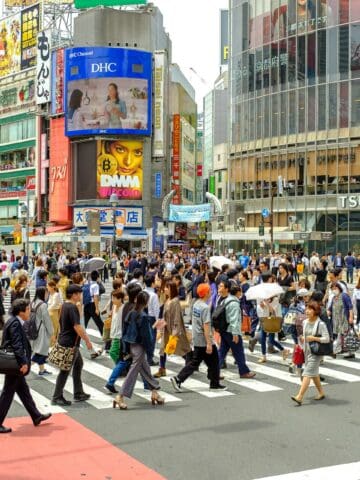 Crowds crossing Shibuya Crossing in Tokyo, Japan during the day