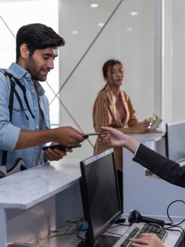 Traveler with backpack presenting passport at airport check-in counter