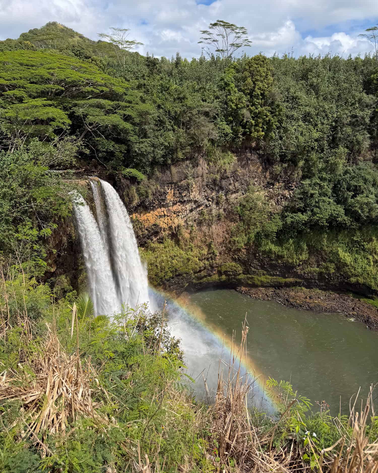 Wailua Falls on Kauai with a rainbow in the mist above the plunge pool