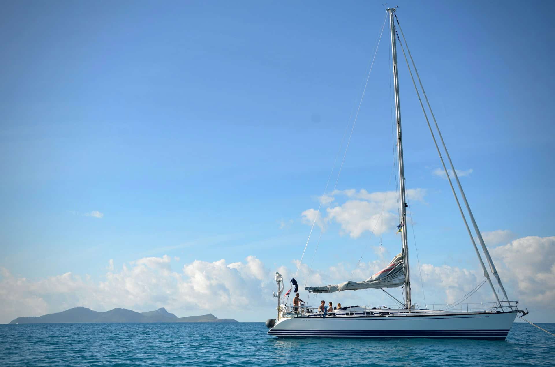 Family aboard a sailing yacht anchored near Whitehaven Beach in the Whitsunday Islands of Australia