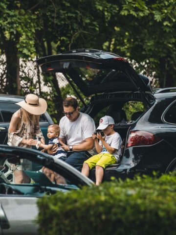 Family unloading an SUV during a road trip stop