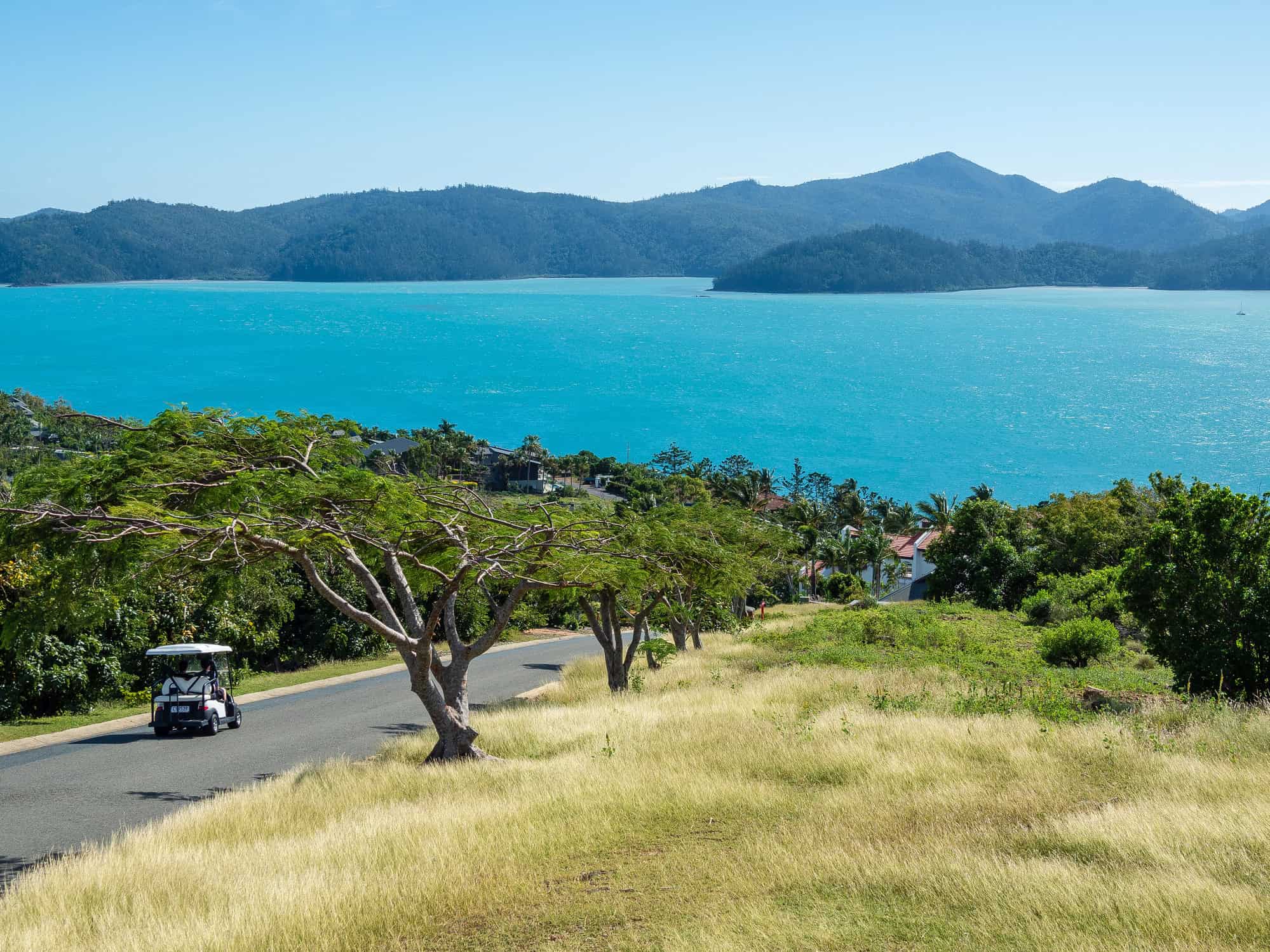 Golf buggy driving on Hamilton Island overlooking the Whitsundays in Queensland, Australia.