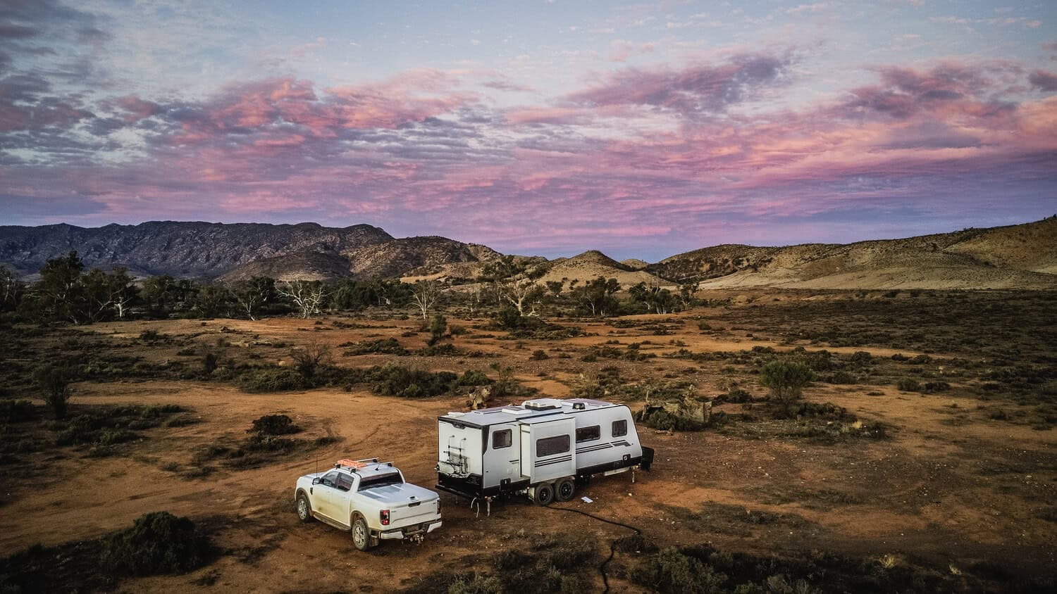 Luxury caravan and pickup truck camping in the Flinders Ranges of South Australia at sunset