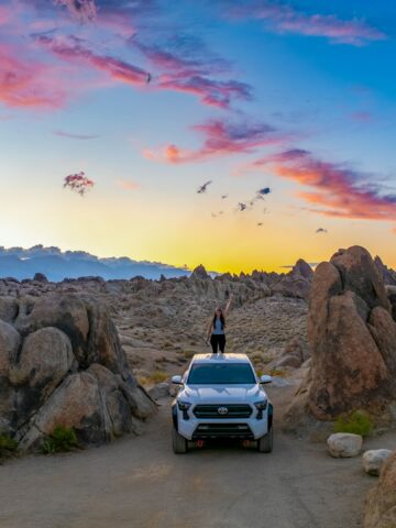 SUV parked in Alabama Hills, California, at sunset during a remote desert road trip