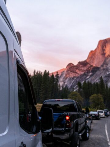 Vehicles parked near Yosemite National Park at dusk during a road trip