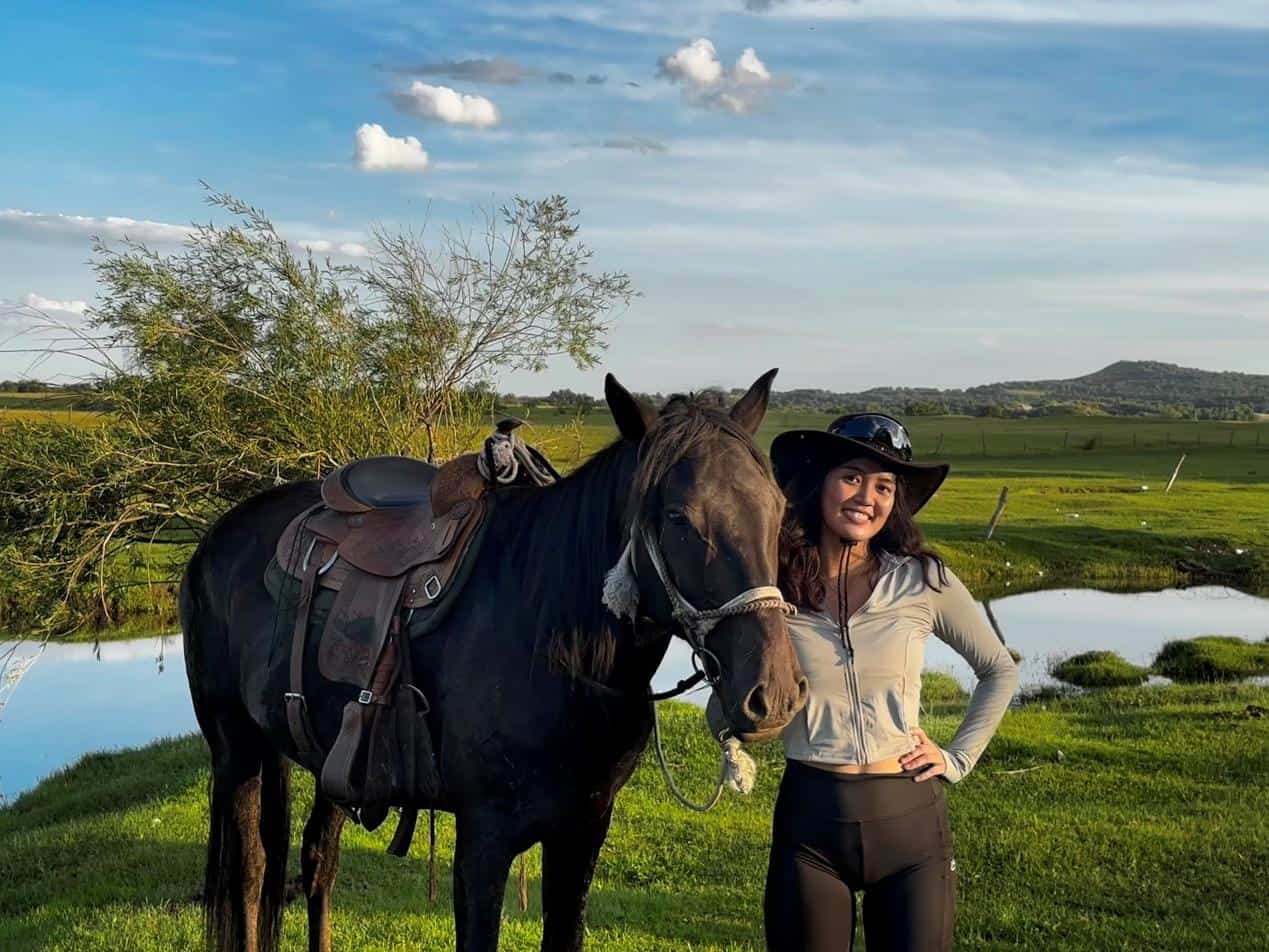 Traveler posing beside a horse during a horseback riding tour near Beijing