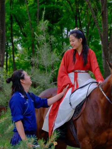 Travelers in traditional Chinese clothing during a horseback riding experience near Beijing